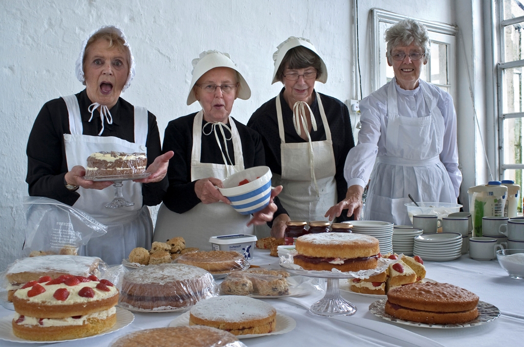 Volunteers in Victorian costume baking cakes