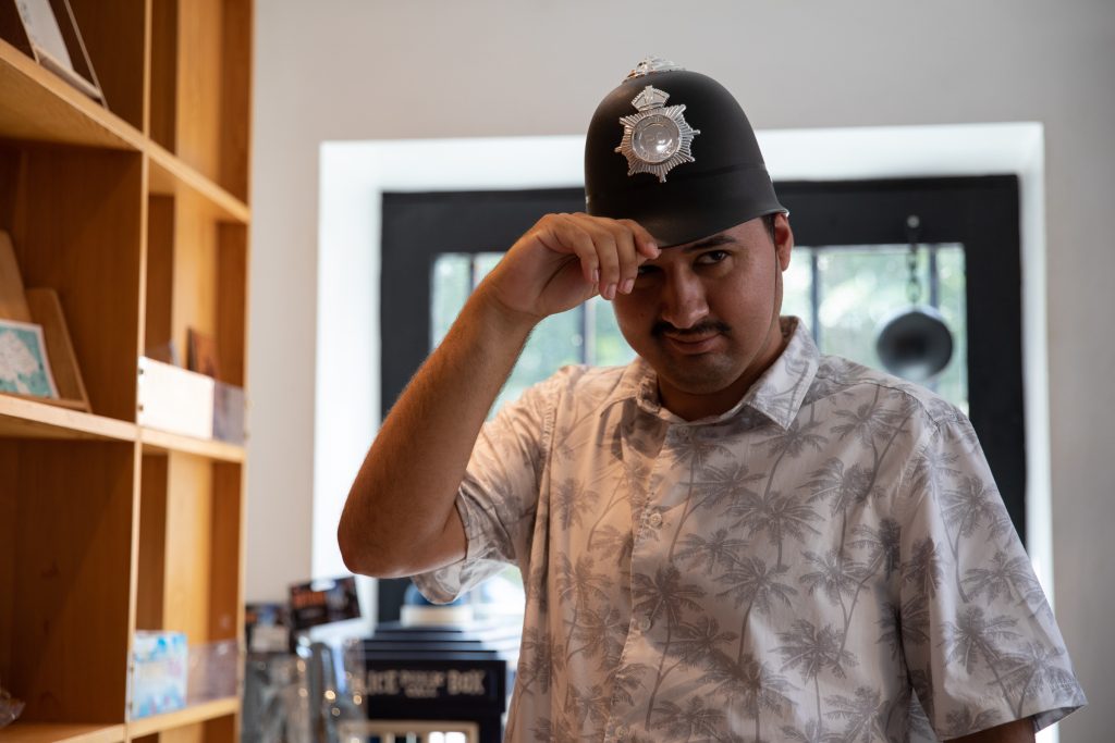 A man wearing a policeman's helmet