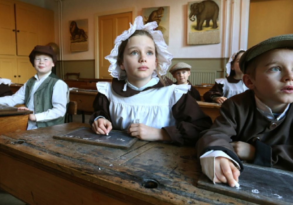 Children in costume in Victorian schoolroom