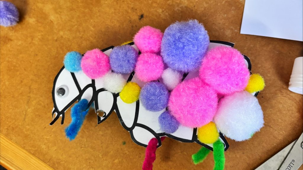 An arts and crafts flea made of pom poms and pipe cleaners