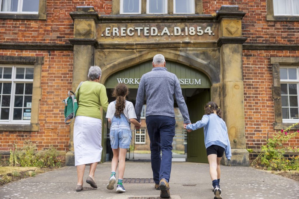A family walk towards the Workhouse Museum